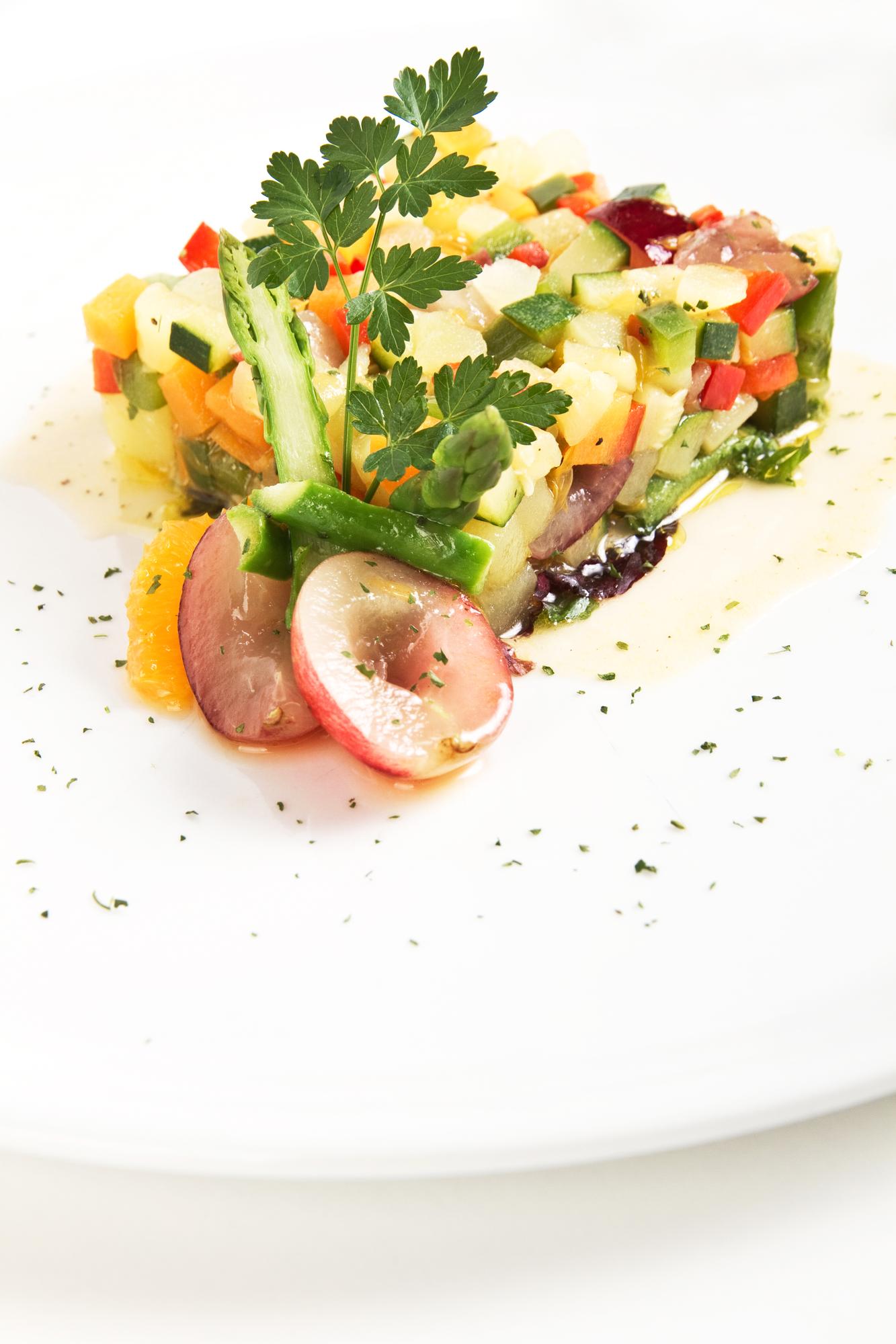 Chef plating a colorful vegetable dish